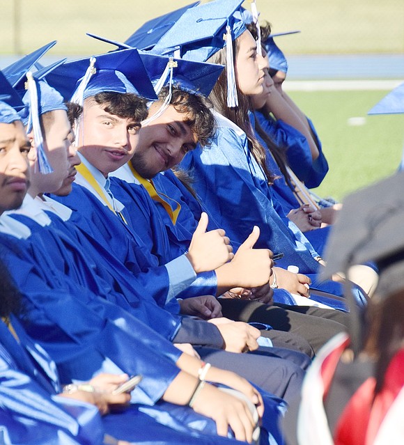 Bayron Aguirre and Brian Aguilera approve of the future! After spotting the camera during the graduation ceremony, they flash a thumbs up.