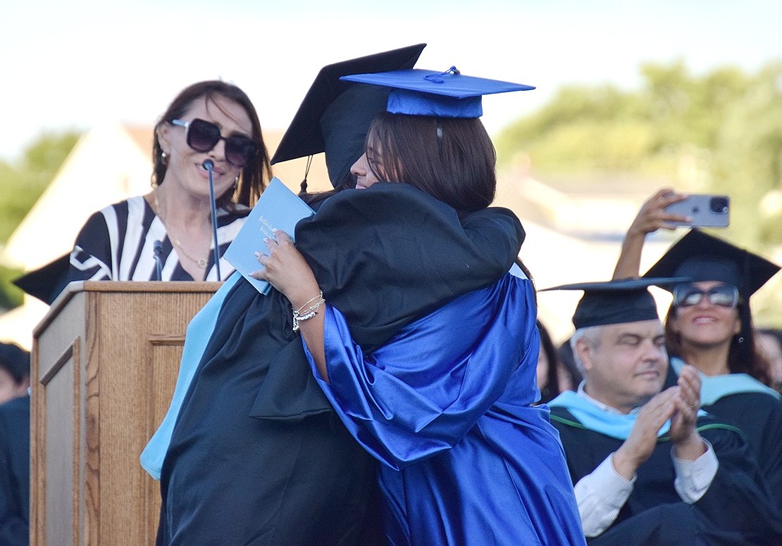 In a sweet moment to remember, Board of Education member Chrissie Onofrio embraces her daughter Jessica Onofrio Franceschini after awarding her a diploma.