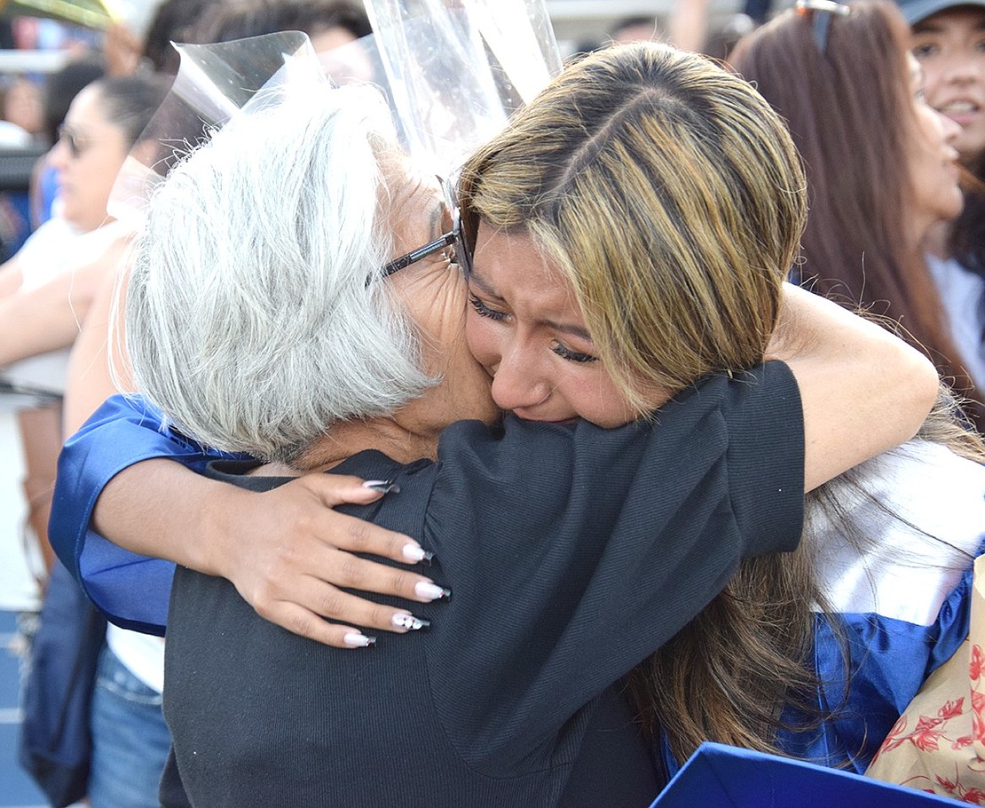 With tears in her eyes, Miah Morban hugs her grandmother Irma Espejo after the ceremony ends and loved ones rush the field to celebrate with their graduates.