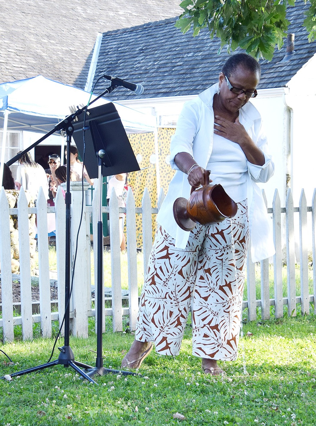 Welcoming the ancestors of the past and kin of the future, Joan Grangenois-Thomas pours libations onto the grass near the Bush Lyon Homestead on June 19 to kick off the annual Port Chester Juneteenth celebration. A Village trustee, she helped found the celebration with the local Historical Society.