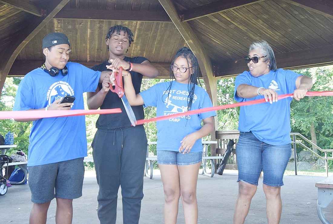 Chase Carroll (left), 15, Ja’Lil Irving, 14, Charlee Hollis, 9, and Janelle Carroll cut a ribbon at the gazebo in Columbus Park on July 1, ceremoniously renaming a longstanding Village of Port Chester summer service to Wanda Irving’s Neighborhood Free Playground Program. Wanda Irving, who died in 2020, created the initiative in 2004.