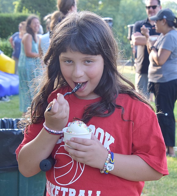 Eight-year-old Hunter Drive resident Samantha Mutis plays to the camera after getting her hands on some vanilla ice cream.