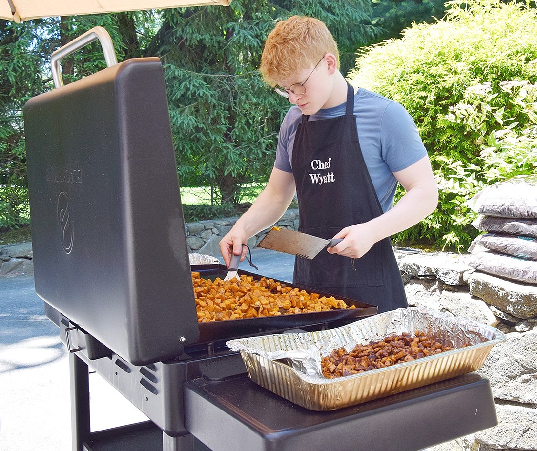 Wyatt Feist, a Blind Brook High School rising senior, cooks up sweet potato home fries during his first “The Hungry Wyatt Pop-Up” event hosted at his Rockinghorse Trail home on June 15. The teenage chef uses his cooking skills to both bond with the community and teach disadvantaged children.