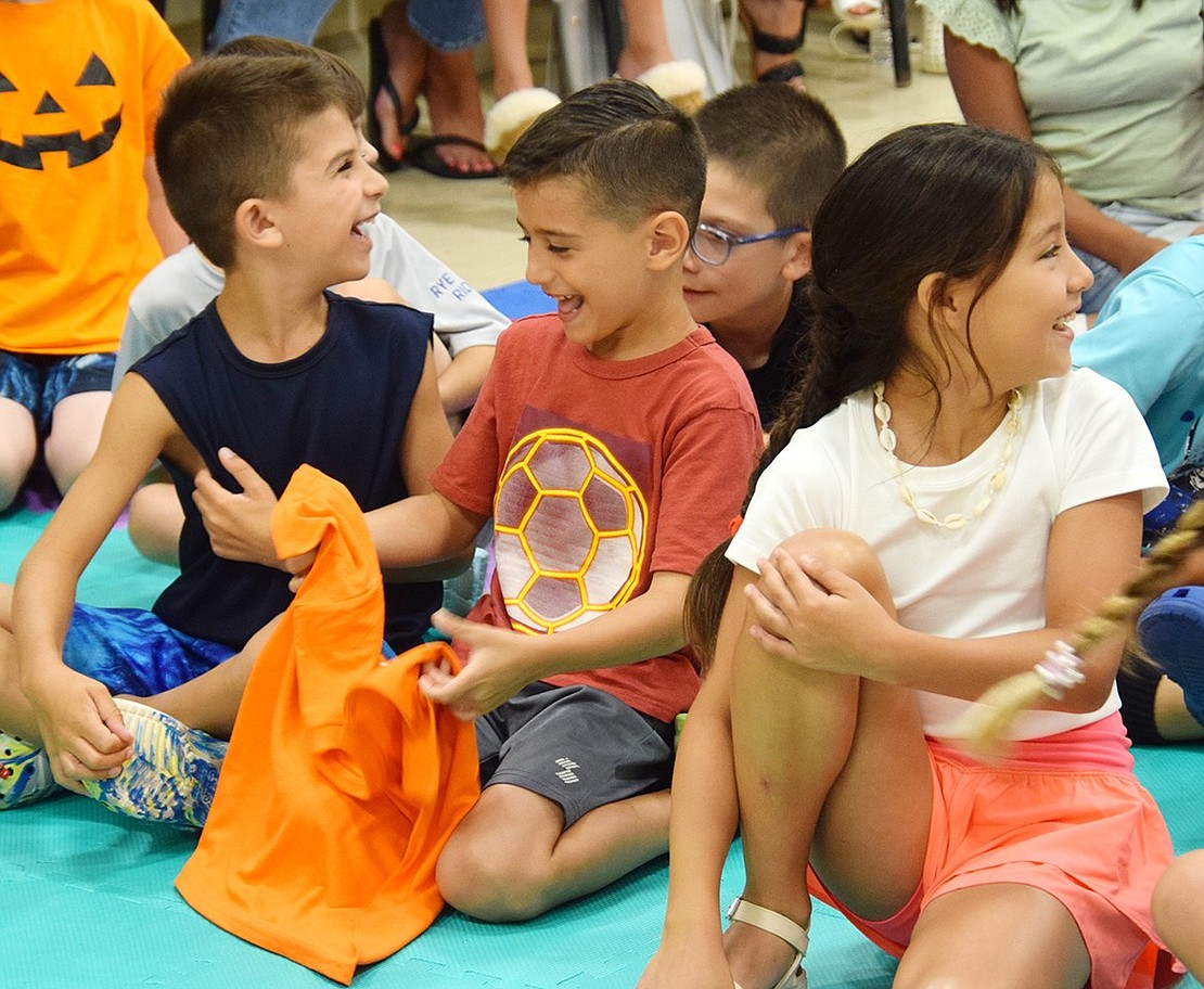 Joseph Fiscella (center), a 7-year-old Cleveland Street resident, giddily holds up a shirt Jester Jim gave him for participating in the show.