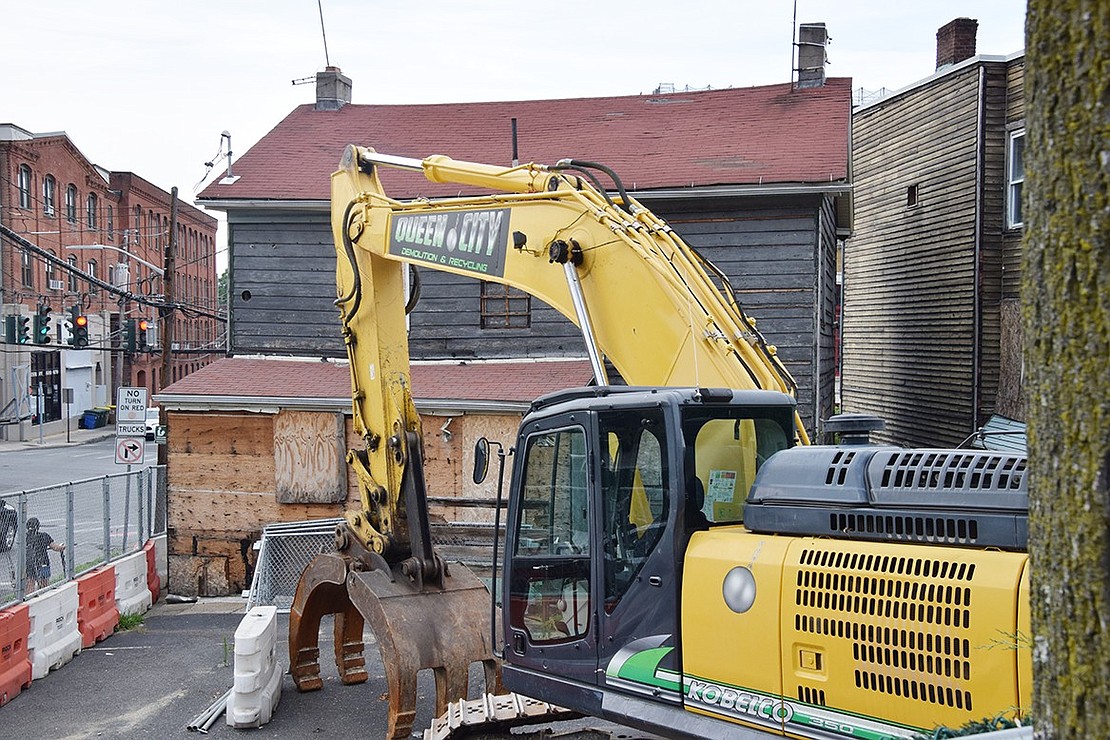 A Queen City Demolition & Recycling excavator is poised to demolish the old wooden structures that stood at 140-150 Westchester Ave.