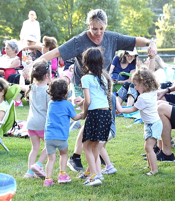 Good music calls for a dance party! Priscilla Picolli, a nanny for the Karasik family of Rye Brook, spins around with several children having a blast at the concert.