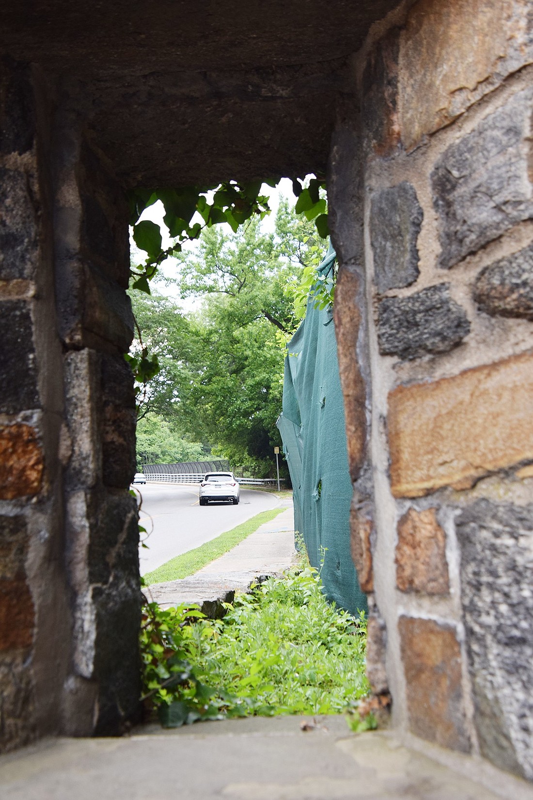 Looking through a stone accessway to the former 999 High St. residential building affiliated with United Hospital, you can see a car pass by on its way along High Street toward South Ridge Street. 999 High St. is slated for demolition this summer.