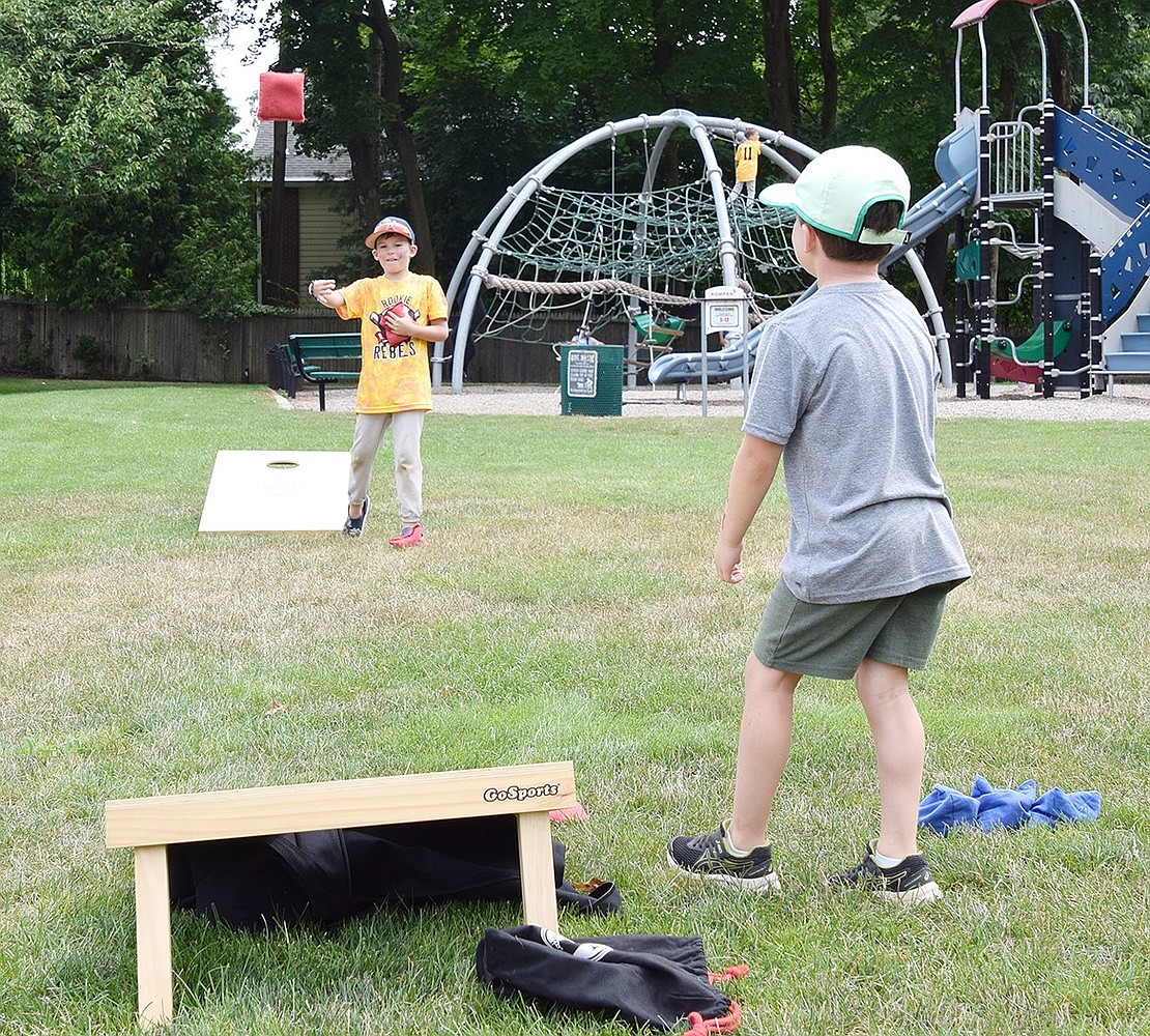 Bonwit Road 5-year-old Spencer Hymen (left), tosses a bean bag during a friendly game of cornhole with Crossway resident Casey Wallace, 6.