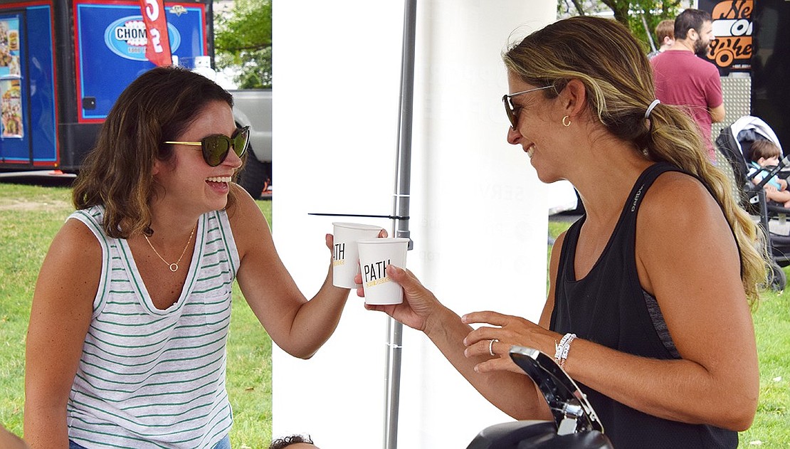 Port Chester natives Jolie Romano (left) and Sara Morabito toast with their free drinks from Path Coffee Roasters, a Port Chester-based roasting company, at Rye Brook’s annual Food Truck Festival on Saturday, July 20. The festivities brought food, games and music to Pine Ridge Park for the community to enjoy.