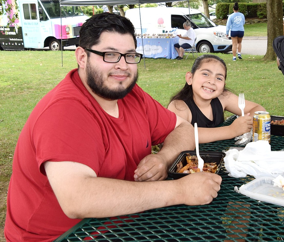 Oswaldo Gudino and his 8-year-old daughter Samantha, of Greenwood Avenue, Port Chester, take a break from chowing down on their meals from Latusion to smile for the camera.