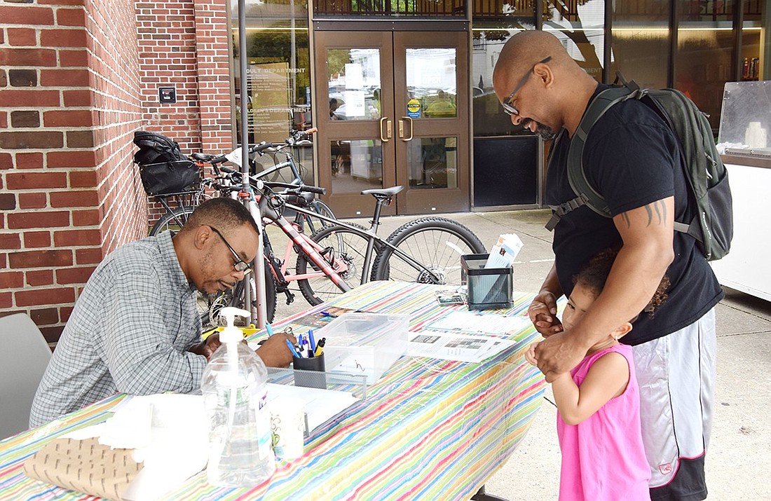 Mark Parham (left) helps Westchester Avenue resident Paul Brown sign his 3-year-old daughter Arya up for the Port Chester-Rye Brook Public Library’s summer reading program at an ice cream social on Tuesday, July 23. The event, hosted by the Village of Rye Brook, was a way to show employees appreciation and to garner interest in the library’s vast array of programs for all ages.