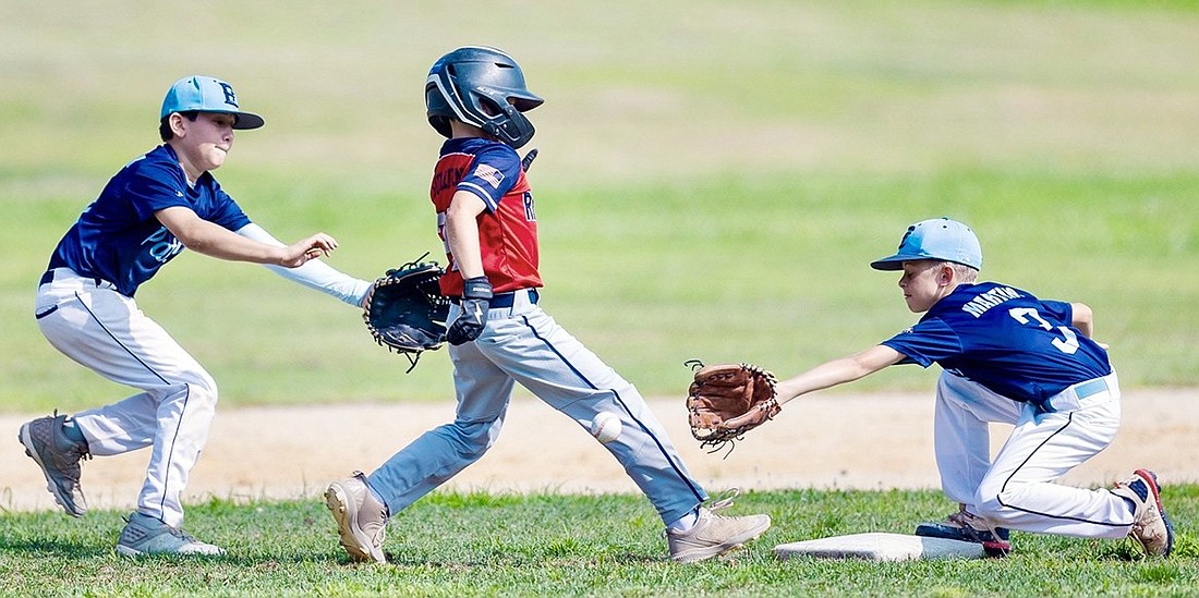 Ryan Sullivan attempts to make it back to second in time as two East Fishkill Patriots try to tag him out in the 11U Rye Brook Rebels’ first game in the Greater Hudson Valley Baseball League playoffs Sunday, July 27 at Ridge Street School.