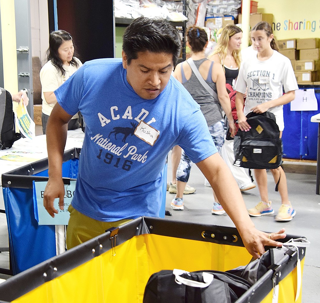 Before bags get cleared for donation, Halstead Avenue resident Kusha Mohammadi transports each one to the quality check station—the last stop on the backpack packing assembly line. This year, The Sharing Shelf will be distributing 1,850 bags filled with school supplies to Westchester children in need.