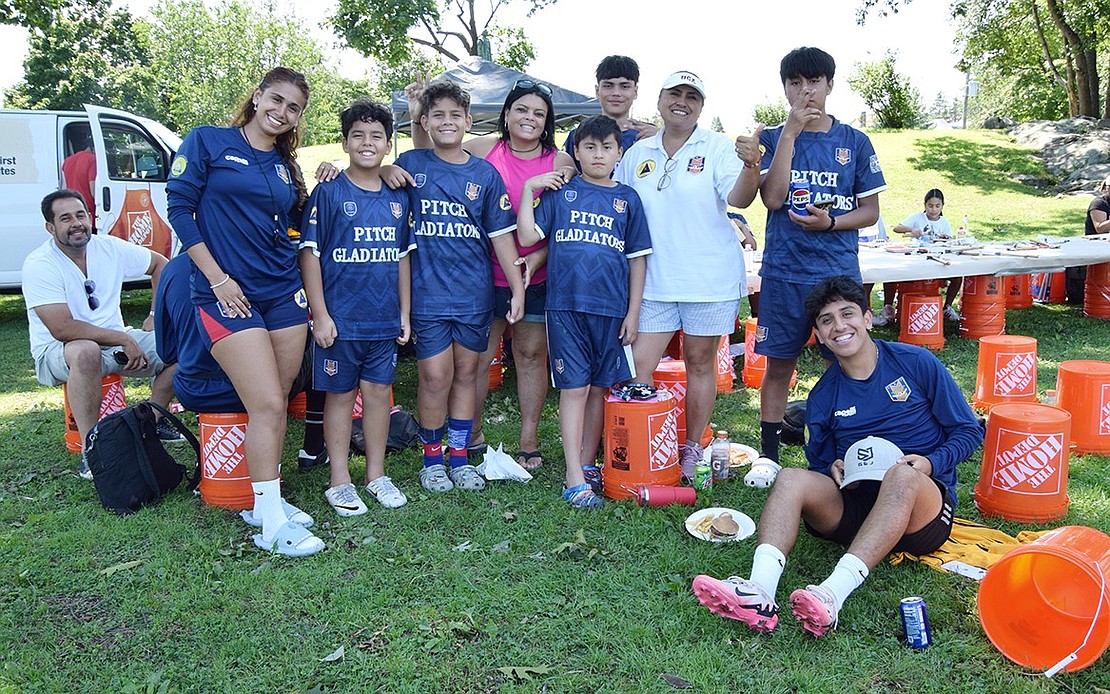 Coaches and players with the Pitch Gladiators Soccer Academy, a Stamford, Conn., organization that also runs clinics at the Columbus Park field, stop by Unity Day to grab lunch after practice.