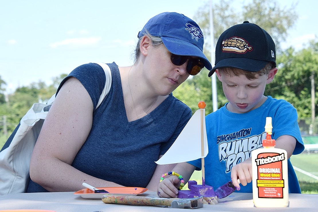 Adding a touch of regality to his sailboat, 3-year-old John Cunningham paints his new toy purple that he built with the help of his mother Colleen Kane at The Home Depot arts and crafts station. Kane is attending the festivities with the Carver Center as the non-profit’s chief advancement officer.