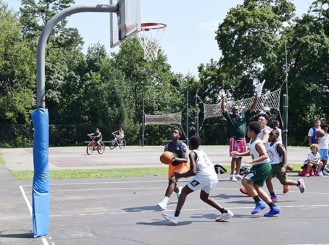 Erickson Lujan, a Port Chester resident who will be in the eighth grade this fall, races by Greenburgh-based opponents to shoot a layup during a Unity Day basketball game at Columbus Park on Saturday, Aug. 10. The annual summertime event serves as a reunion for current and former Village residents by bringing folks together for a cookout and to watch basketball games.