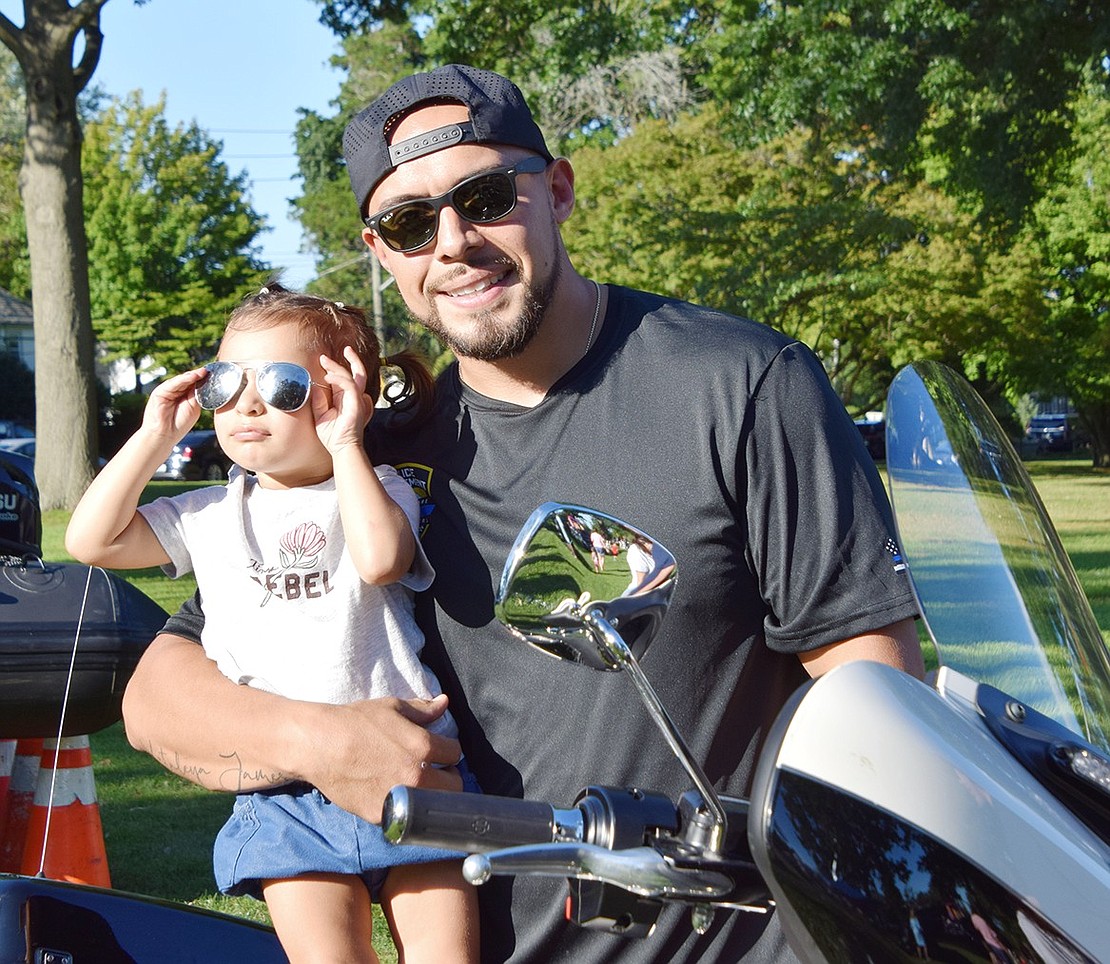 Looking cool with a pair of shades, 2-year-old Kataleya Cardenas poses with her dad, Officer Josue Cardenas, on a police motorcycle.