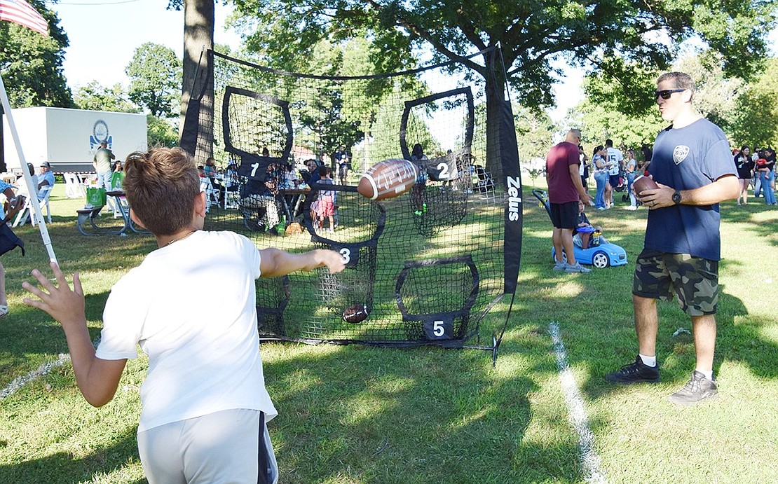 Port Chester resident Harrison Burt, 6, shows off his arm at a net set up to test attendees’ football skills.