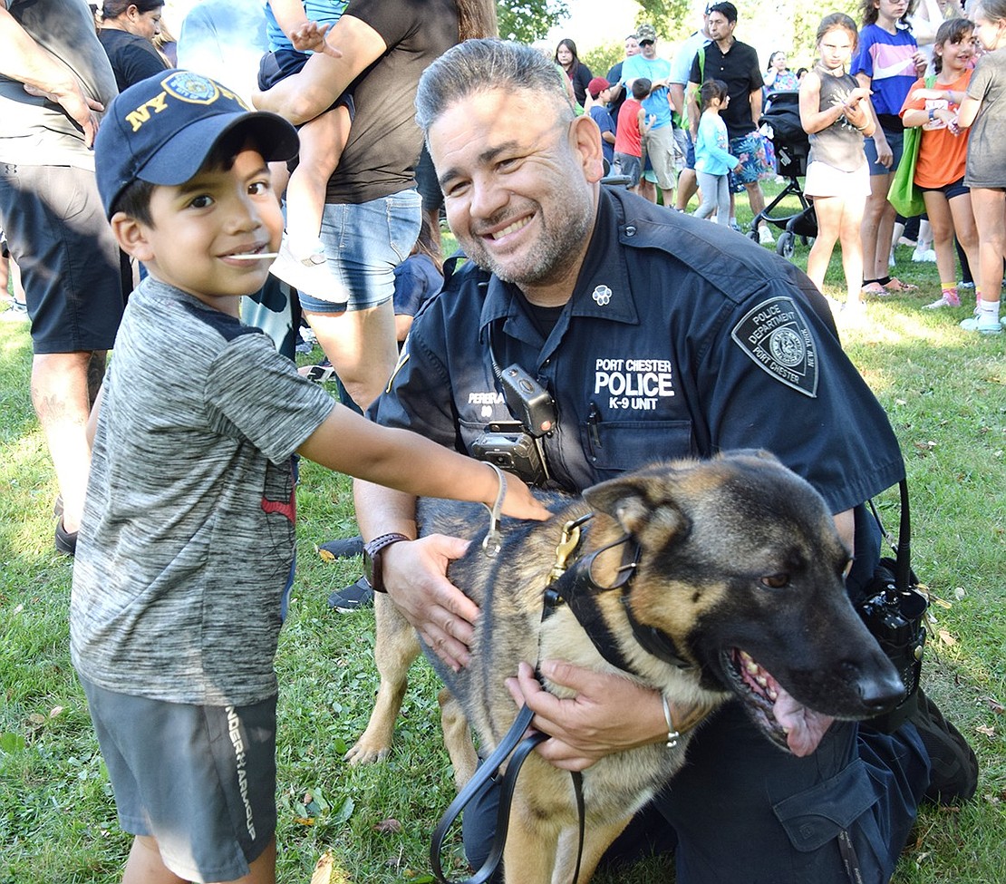 Davenport Avenue resident Matteo Rodas, 4, meets Port Chester Police Officer Marcelo Pereira and his partner, K9 Officer Mac with delight at the annual National Night Out event.