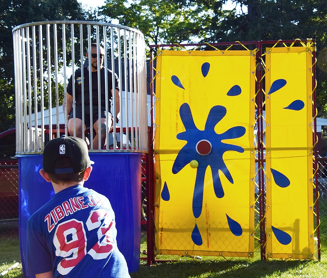 Chase Krzeminski, the 6-year-old son of Port Chester Police Lieutenant Christopher Krzeminski, narrowly misses the target while trying to plunge Officer Josue Cardenas into a dunk tank at the fifth annual National Night Out on Tuesday, Aug. 13. Hundreds gathered at Lyon Park to bond with the local police force over fun, games and food.