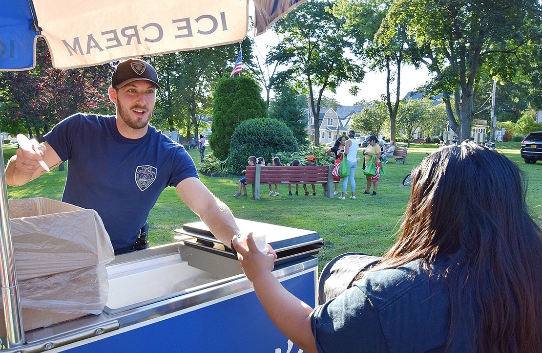 Detective Joseph Romanello takes a shift distributing frozen treats to attendees.