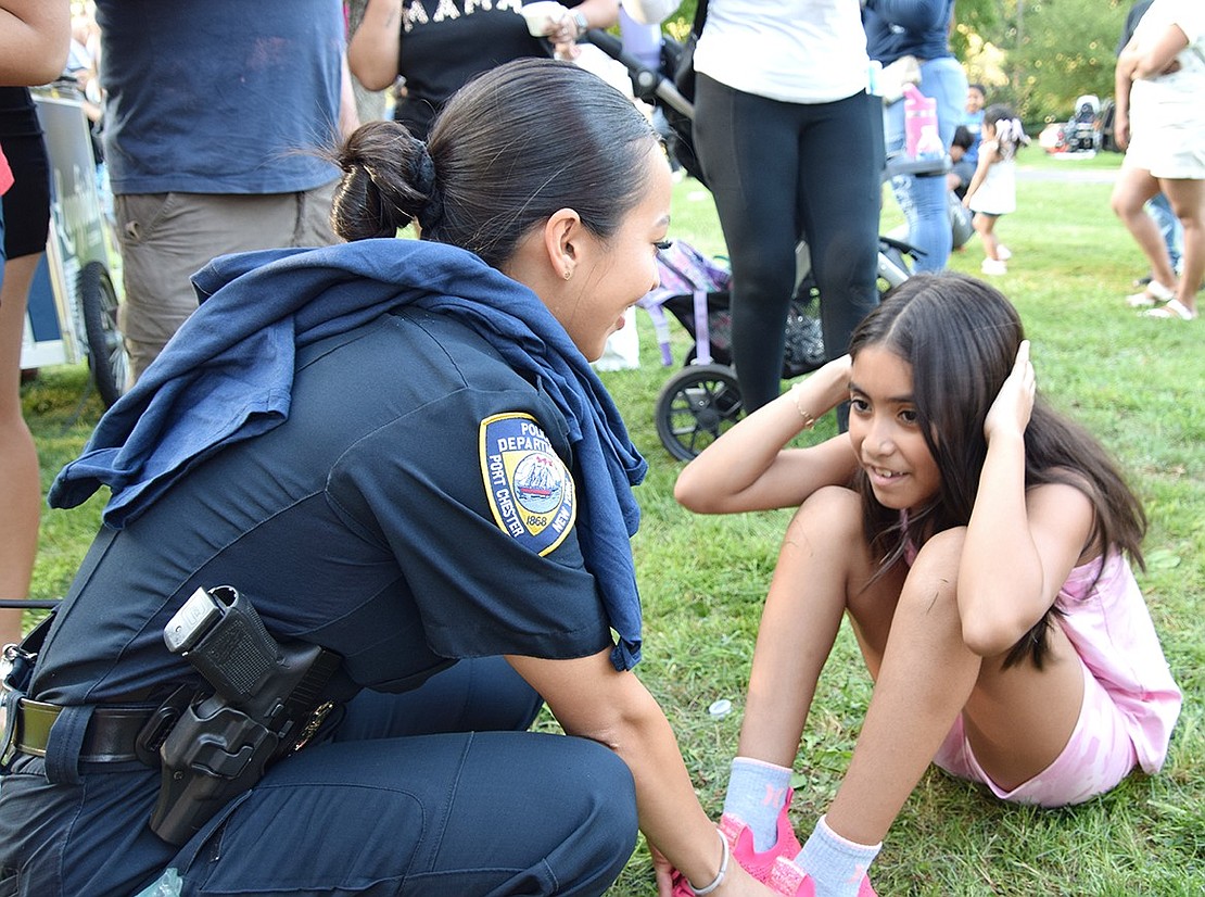 Officer Leslie Gutelius has Kiara Pantoja, a Willett Avenue 9-year-old, do 15 sit ups to earn a National Night Out T-shirt.