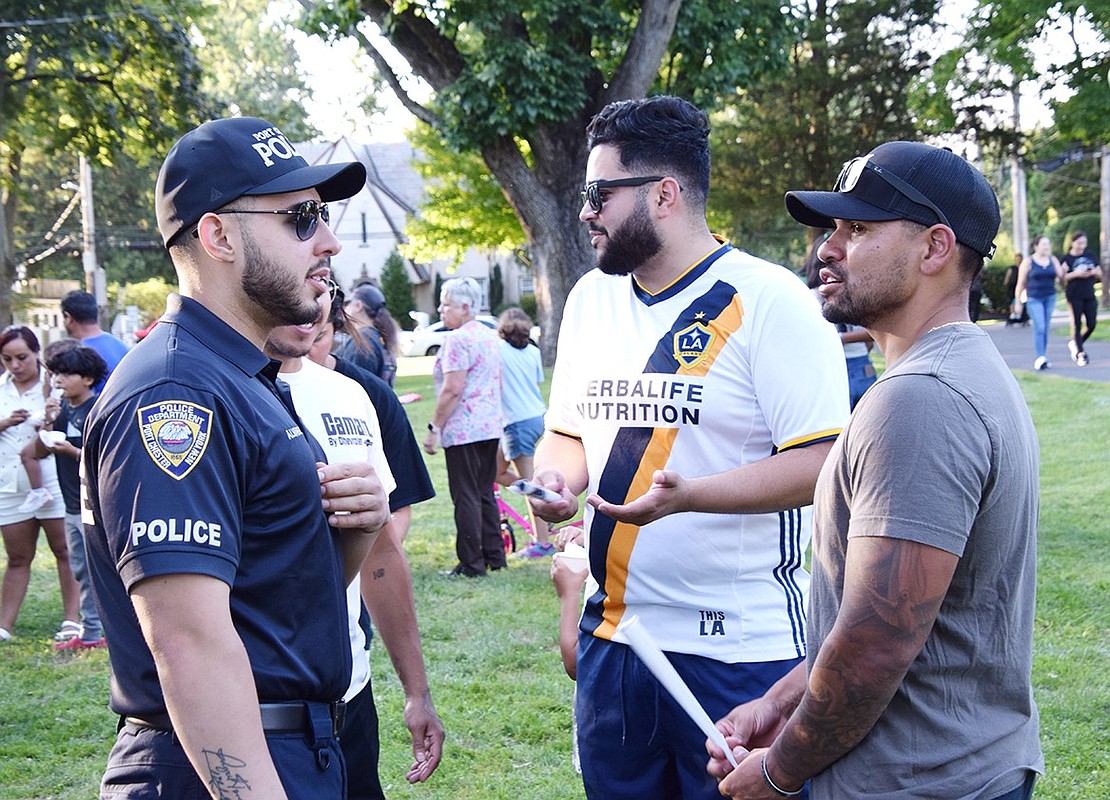 After drying off from his shift in the dunk tank, Officer Steven Alvarez (left) takes some time to speak with Rye Brook resident Christian Leoni and Kevin Iglesias of Bolton Place.