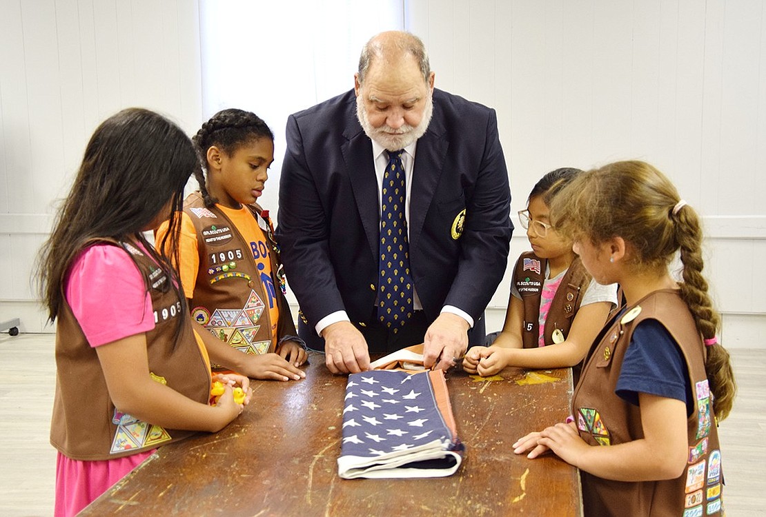 Knights of Columbus member and Port Chester resident Charlie Sacco shows Port Chester/Rye Brook Troop 1905 Girl Scouts the proper technique to fold an American flag for its retirement on Thursday, Aug. 15. The troop collected flags across the Town of Rye to retire them by burning, in accordance with the U.S. Flag Code. The Scouts are, from the left: Alejandra Chica, Savannah Jones, Sofia Parra and Sophia Labrusciano.