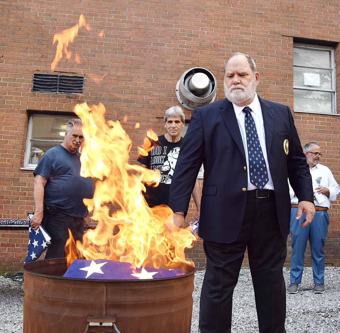 Charlie Sacco, a member of the Knights of Columbus John M. Grady Council 503 in Port Chester, watches intently as flags are burned during the group’s annual flag retirement ceremony at their 327 Westchester Ave. headquarters.