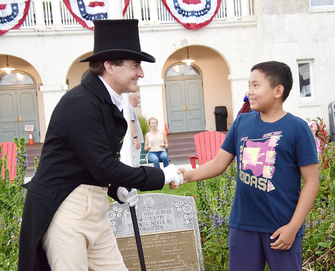 Mark Schneider, portraying the Marquis de Lafayette, shakes hands with Brendan Park, a rising fifth-grader at Ridge Street Elementary School, at Rye Town Park on Sunday, Aug. 18. The reenactor spent the day traveling through Westchester as part of the bicentennial celebration of Lafayette’s national tour in 1824.