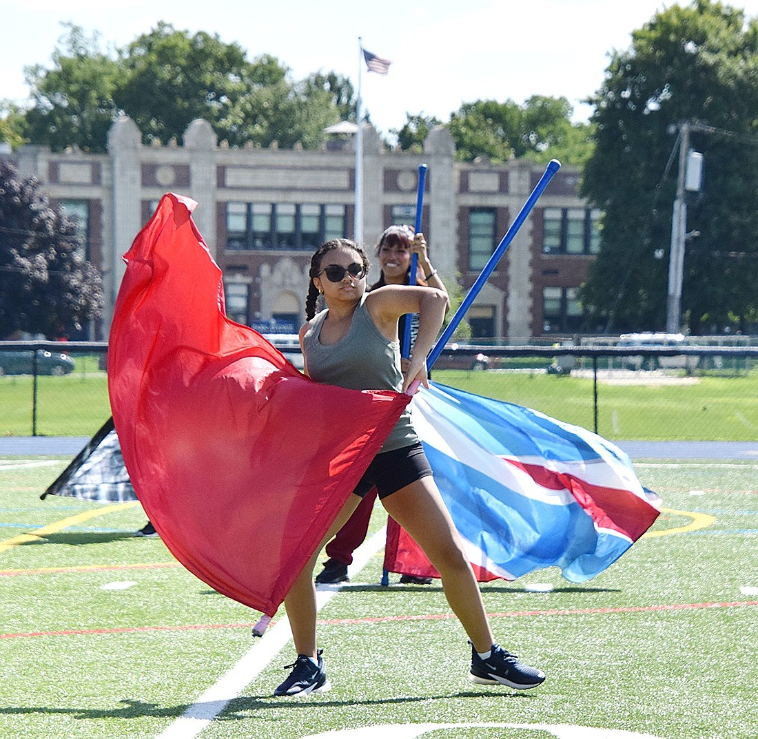 Ava Garcia, a junior color guard member with the Pride of Port Chester, circles a red flag around her body during a Band Camp rehearsal on Tuesday, Aug. 20. Band Camp, where students are preparing to present the visually appealing “Flight of Fire” show, was held entirely on the Port Chester High School football field this year.