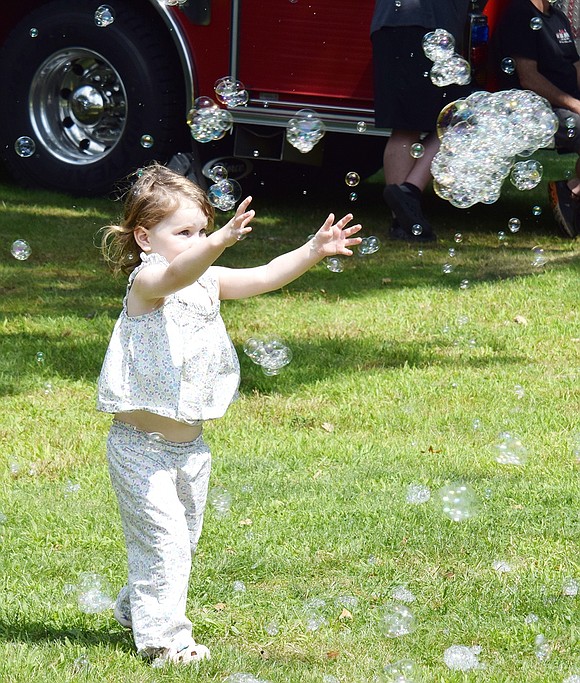 Colette Trenholm, a 3-year-old Alden Terrace resident, chases after some bubbles floating around the park.