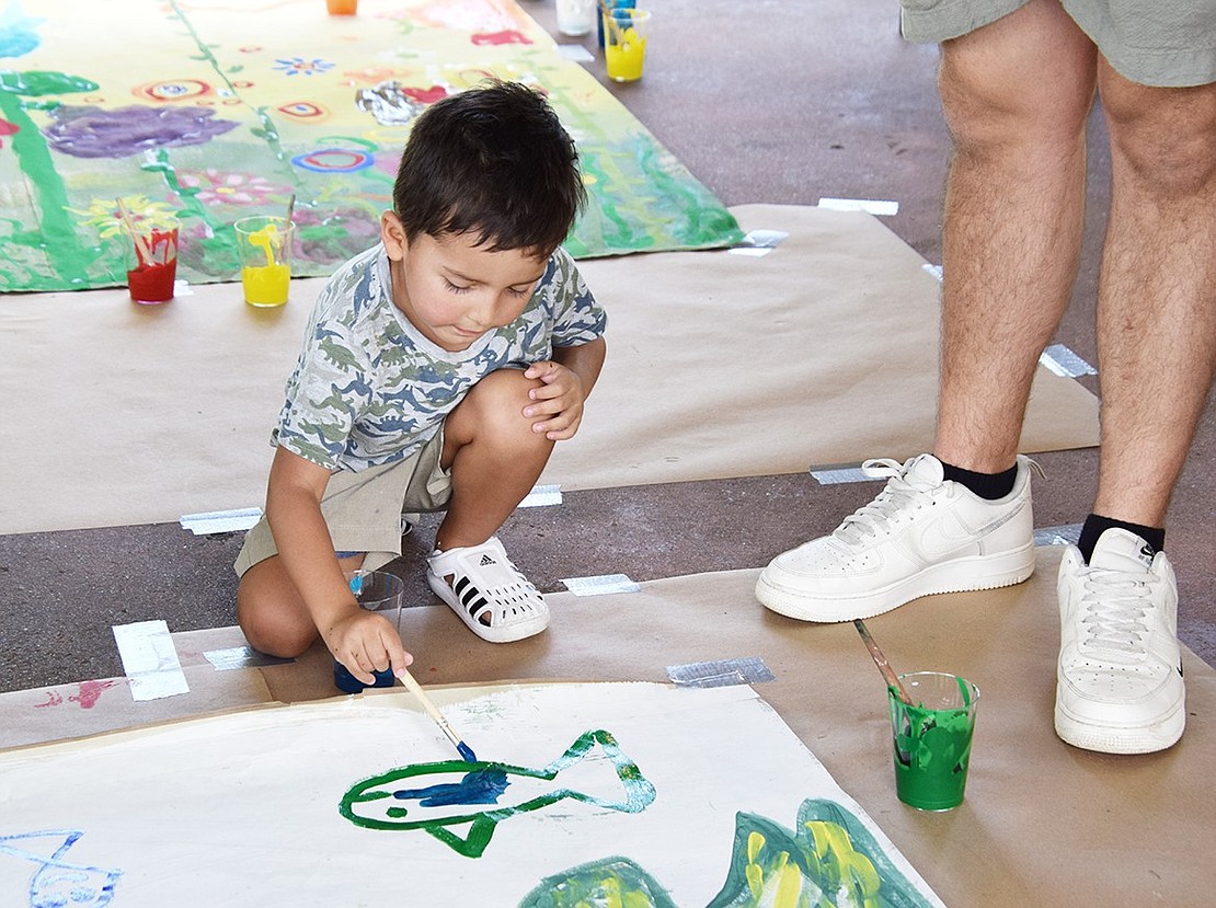 With a careful stroke of his brush, 4-year-old Merritt Street resident Logan Zagami contributes to an ArtsWestchester mural by painting a fish.