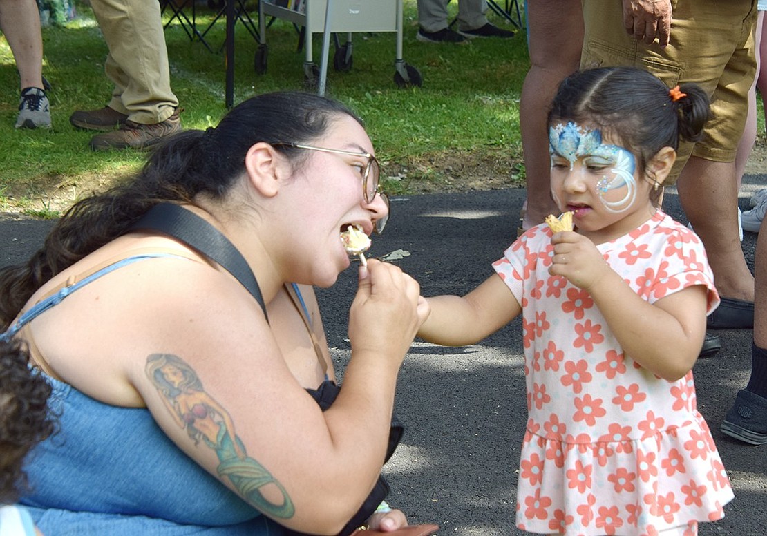 In a mother-daughter bonding moment, Ellendale Avenue resident Emily Vasquez (left) takes a bite out of 3-year-old Layla Chavez’s cake pop.