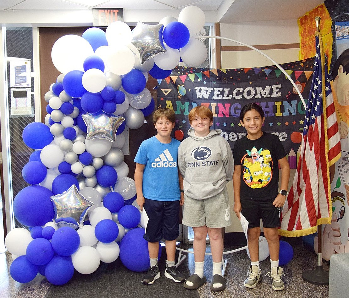 Cooper Pearce (left), Daniel DeFreitas and LJ Sherwood pose for the camera in the lobby of their new school.