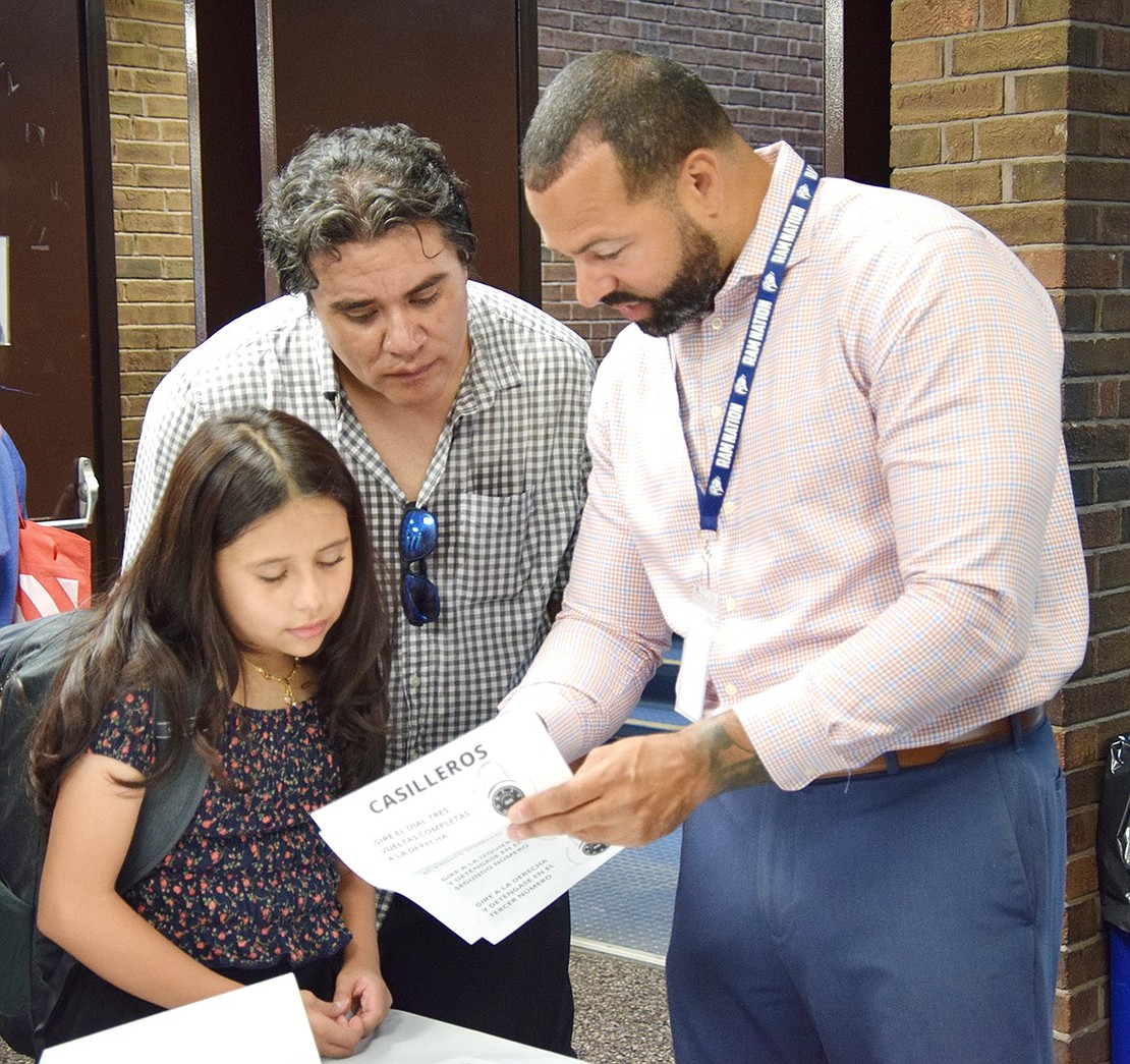 Danna Andrade, an incoming Port Chester Middle School sixth-grader, and her dad Jorge look over her class schedule with her new principal Bryant Romano during Locker Opening Day on Tuesday, Aug. 27. Students visited the building that day to check out their courses, explore the school and practice opening their lockers.