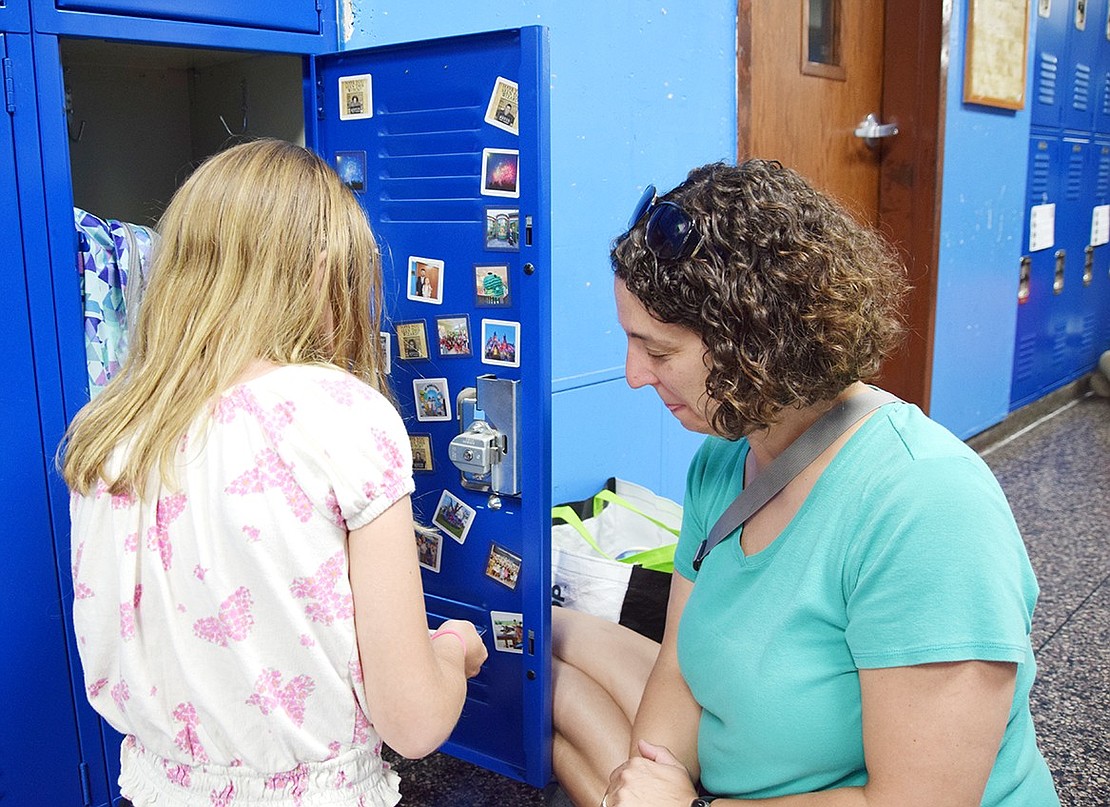 Arianna Butkiewicz, a rising sixth-grader who lives on Locust Avenue, gets started decorating her locker with magnets as her mom Marissa Torento-Butkiewicz reminisces about how she did the same at her age.