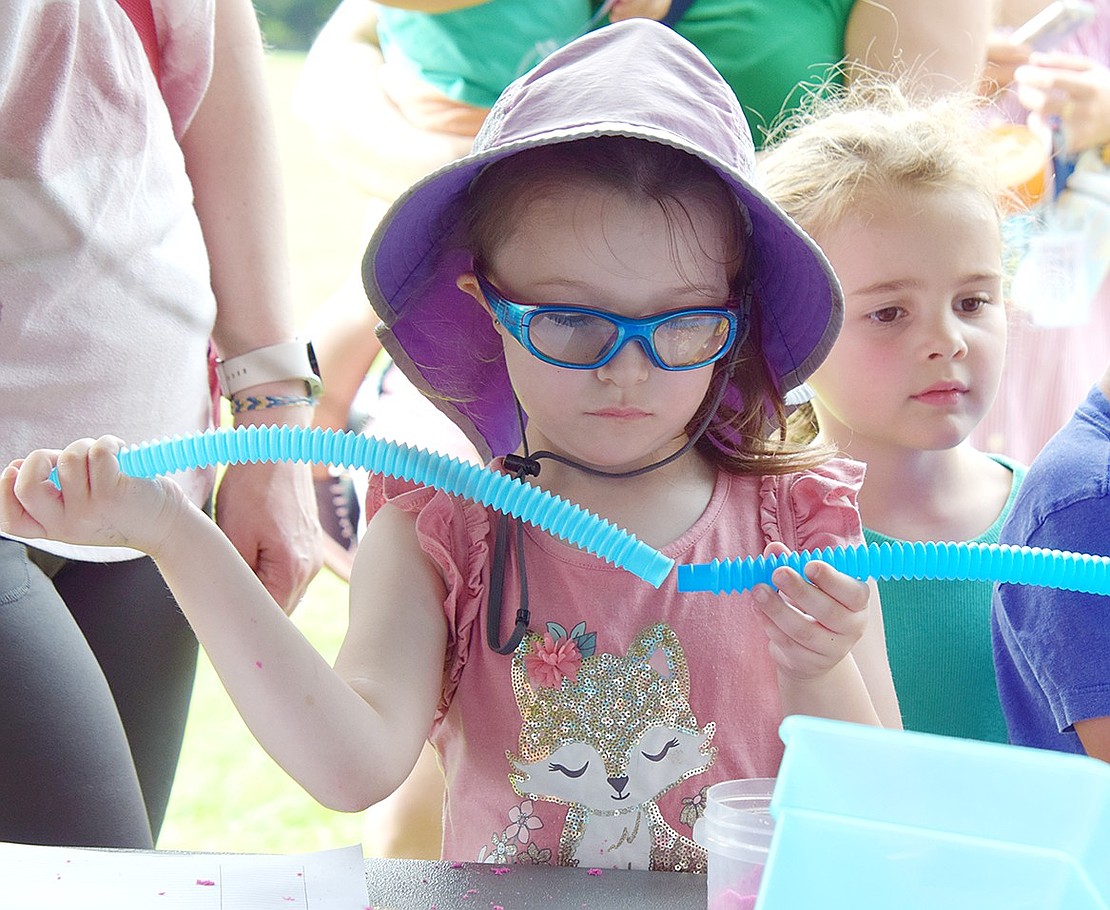 Ready to tinker like a young engineer, incoming kindergartner Lada Sidelev works to piece together two plastic tubes she found at a toy station.