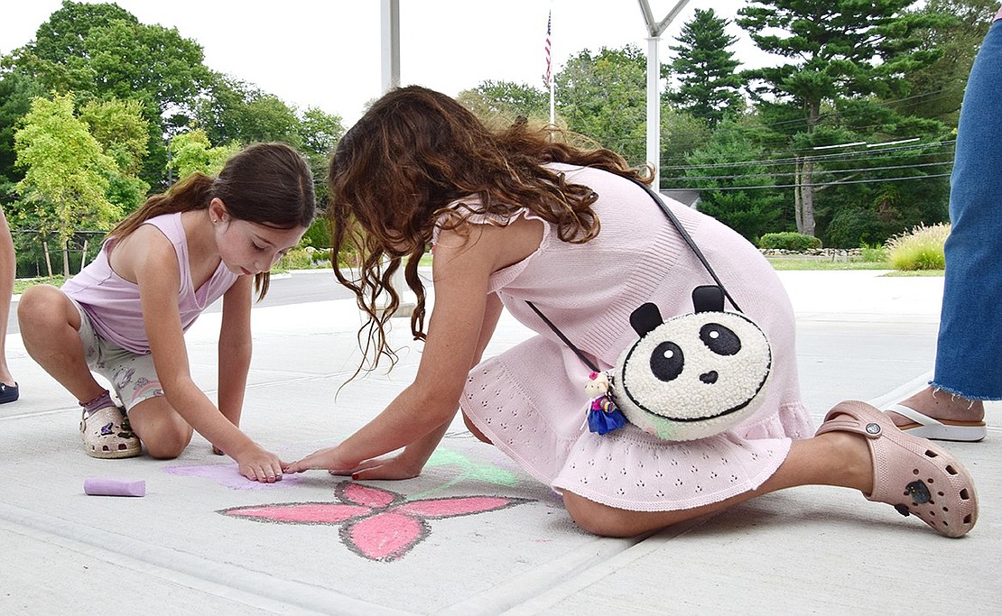 North Ridge Street sisters Catherine (left), 7, and Christina Iarocci, 9, decorate the sidewalk in front of Ridge Street School ahead of their first day of second and fourth grades during the Blind Brook PTA’s Chalk the Walk event on Saturday, Aug. 31.