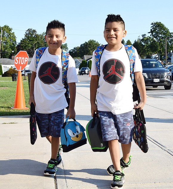 Identical twins José (left) and Jorge Ambrosio, of Bulkley Avenue, are all smiles as they walk into King Street School with matching clothes, backpacks and sneakers on their first day of third grade.