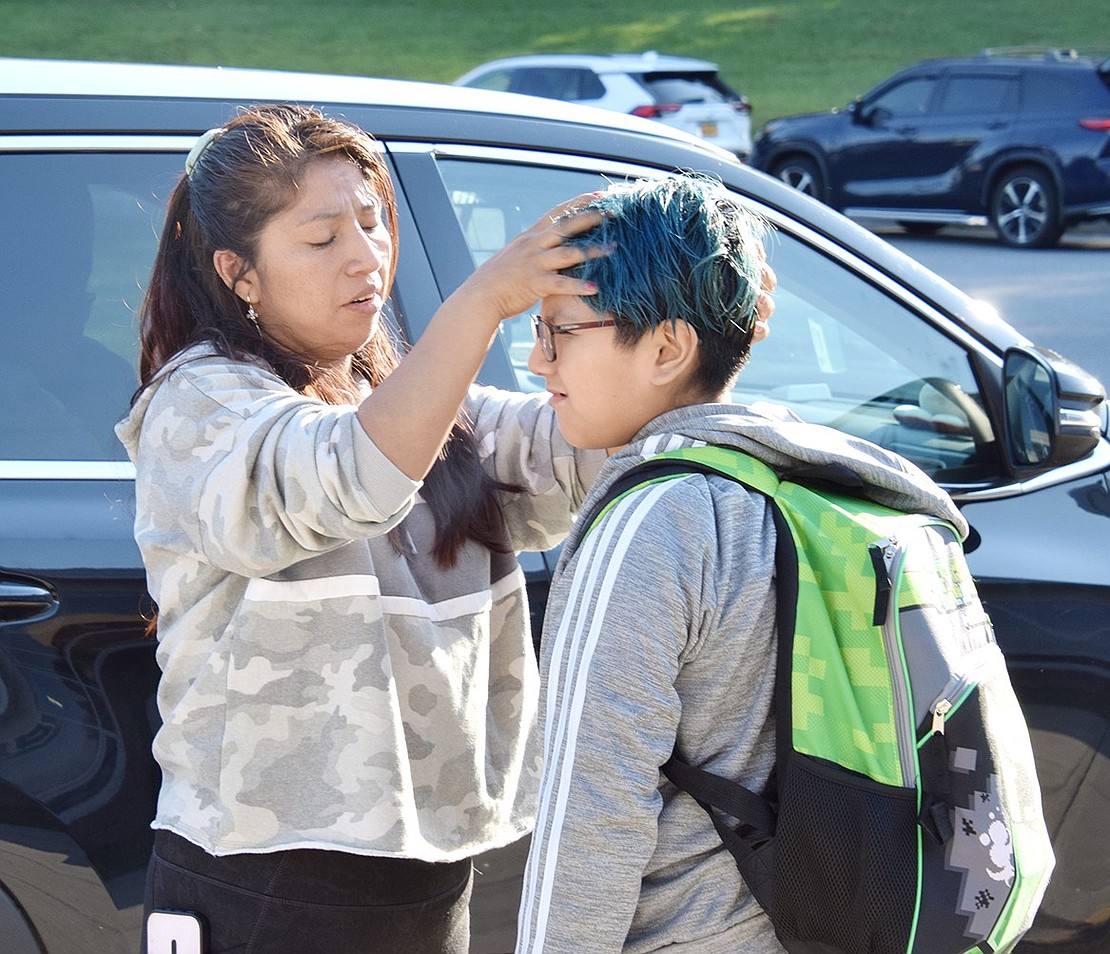 Elsa Naula of Parker Street makes some last-second adjustments to her son Matthew’s hair in the King Street School parking lot before he steps into his fourth-grade classroom.