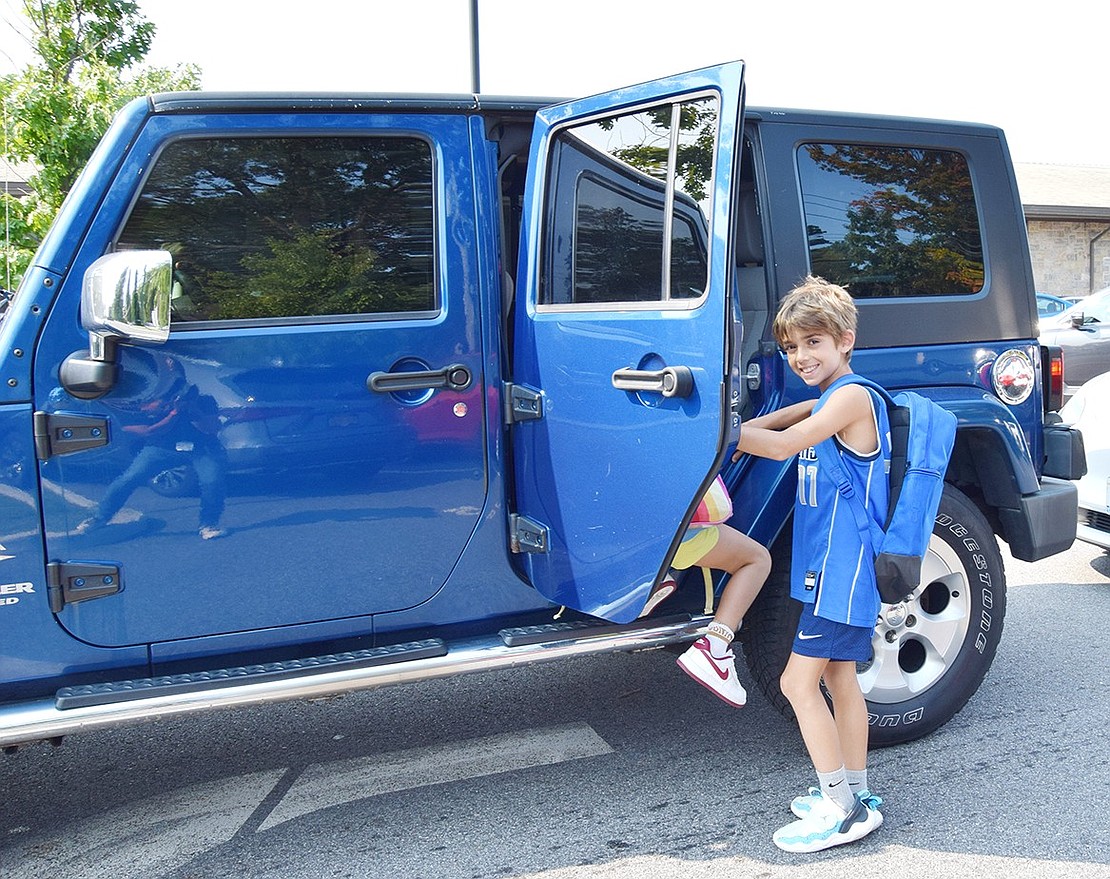 Third-grader Kaden Firestone, a Rock Ridge Drive resident, pauses to smile for the camera before climbing into a vehicle for his ride home.