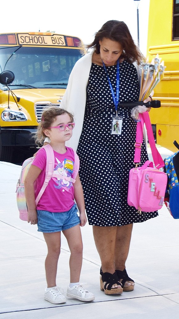 Ridge Street School Principal Tracy Taylor takes a moment to walk one of the newest Bluebirds, kindergartner Gianna Spohrer, onto a bus home.