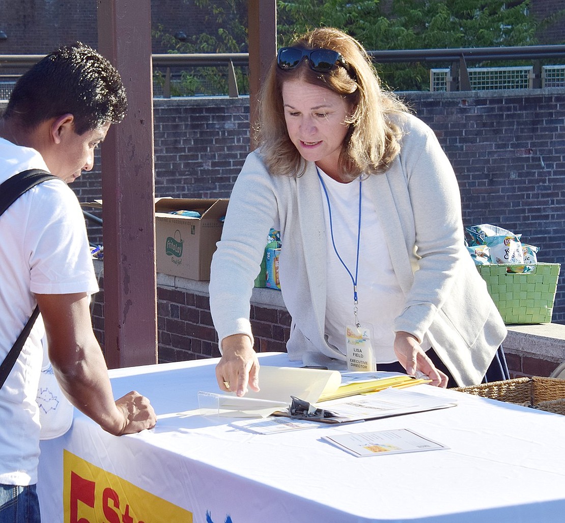 Lisa Field, executive director of Five Steps to 5, passes out information about the Port Chester organization’s parenting program to attendees visiting her table. She was among several representing local community resources at the Back to School Bash.