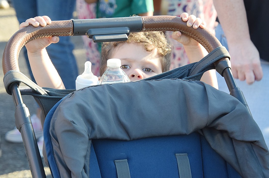 While his middle school-aged brother is off playing with friends, Luca Giordano hangs back with his parents and takes a turn behind the wheel by pushing around his stroller.