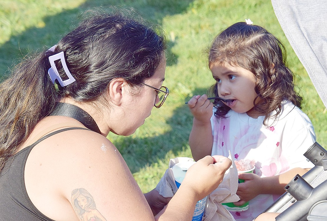 Universal Pre-Kindergarten student Layla Chavez enjoys a sweet, icy treat with her mother Emily Vasquez.