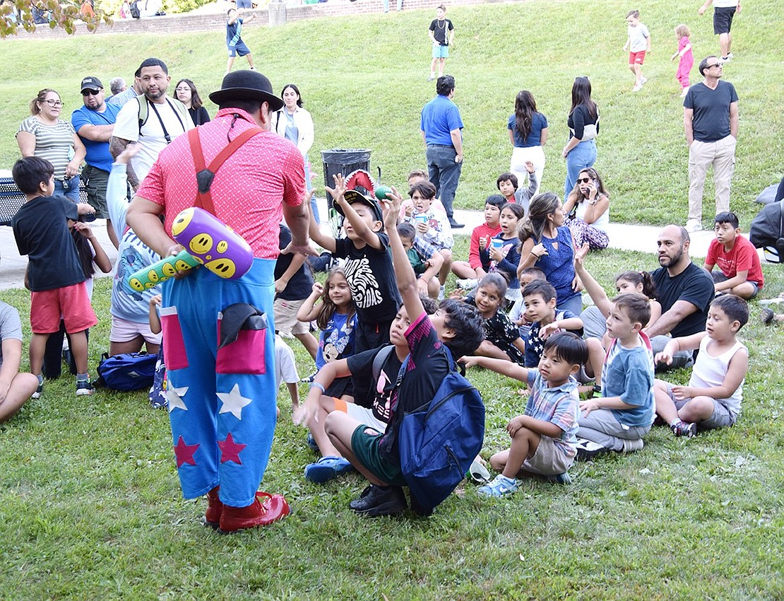 The continuously playing clown show had children roaring with laughter and eager to participate for a chance to win a prize, such as the inflatable hammer he holds behind his back.