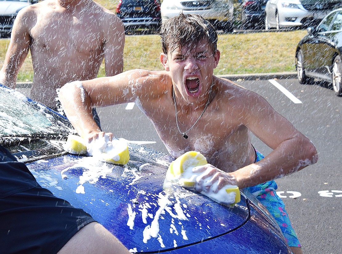 Chase Katz, a Blind Brook High School senior, furiously washes a car during the boys’ varsity soccer team’s annual car wash fundraiser in the Middle/High School parking lot on Saturday, Sept. 14.