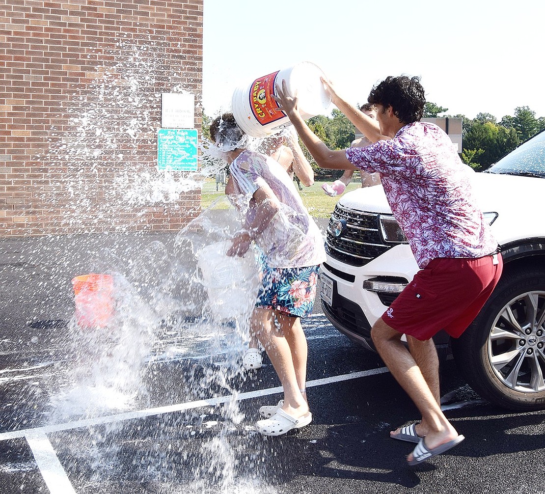 Senior Luka Cuk (right) catches freshman Thomas Maniscalco by surprise, drenching him while they finish rinsing off a car.