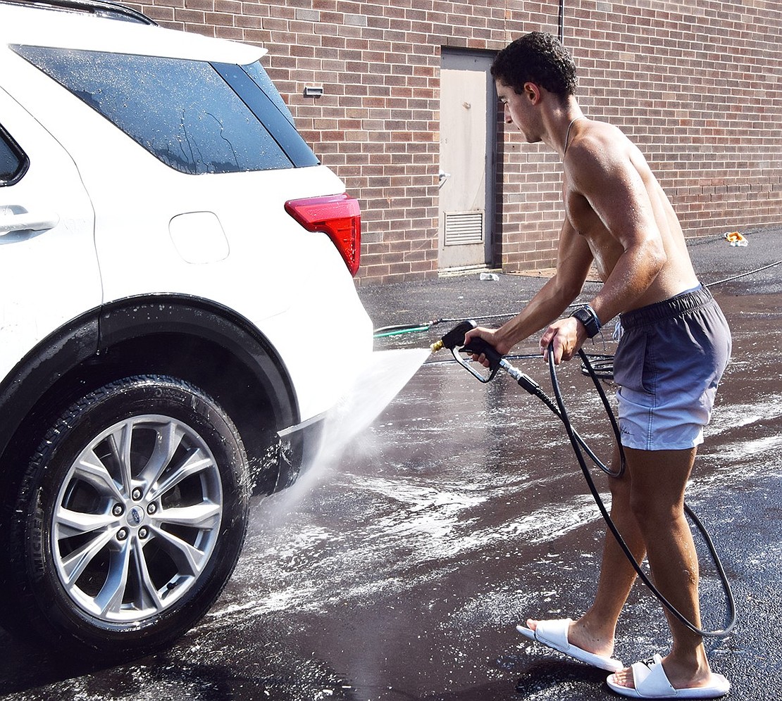 Senior captain Henrique Almeida hoses down an SUV.